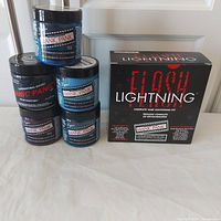 Group shot showing five color cream jars stacked beside Flash Lightning kit box