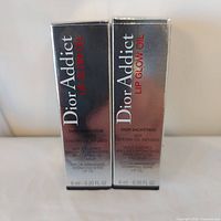 Front view of two boxed Dior Addict Lip Glow Oil units