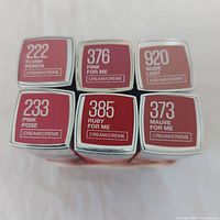 Shade labels of six Maybelline lipsticks showing numbers and names