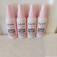 Front view of the four NYX spray bottles standing side by side