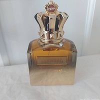 Front view showing SCANDAL plaque and amber gradient bottle