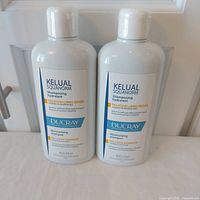 Two sealed Ducray Kelual Squanorm shampoo bottles front view