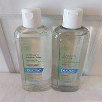Front view of both Ducray Sensinol shampoo bottles