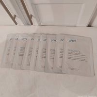 Nine PMD Recovery sheet mask pouches laid out flat