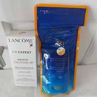 Lancome boxed sunscreen and Shiseido sealed sunscreen stick in pouch
