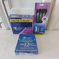 Overall lot showing Whitestrips box, toothpaste value 3-pack, Oral-B toothbrush 4-pack