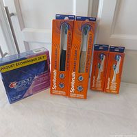 Full lot showing two toothbrush boxes, two replacement head packs, and three-pack toothpaste