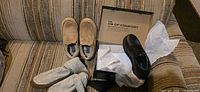 Overview showing all three pairs: black shoes in box, tan slippers, grey slipper socks
