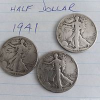 Obverse of three 1941 Walking Liberty half dollars on lined paper