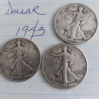 Obverse of three 1943 Walking Liberty half dollars on paper showing date