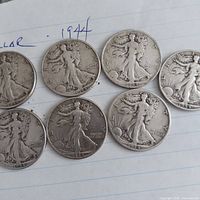 Seven 1944 Walking Liberty half dollars obverse side on paper