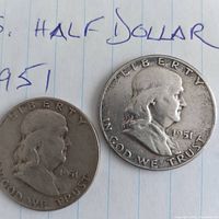 Obverse view of two 1951 Franklin half dollars on lined paper