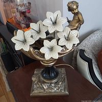 Full view of figural lily lamp showing metal cherub, bowl, and glass shades