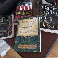 Group of four books: Whispered Lies, Smash Cut, The Defector, The Memoirs of Elizabeth Frankenstein