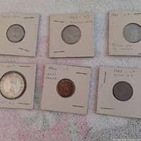 Overview of six coins in 2x2 flips with handwritten dates and denominations