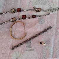 Lot overview showing three bracelets, bangle, and belt section
