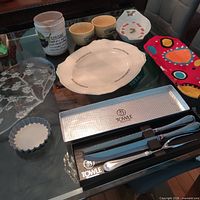 Group shot displaying Towle carving set in box and assorted kitchen serveware pieces on glass table