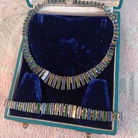 Necklace and bracelet laid in velvet-lined case showing full design and inlay colors