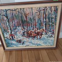 Front view of framed needlepoint showing full winter scene and frame