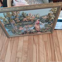 Framed needlepoint artwork showing scene and frame