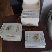 Boxed set of small white hardcover Beatrix Potter books beside slipcase