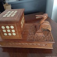 Overall dispenser showing cube with inlays, carved base and bird lever