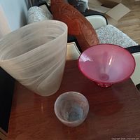 Large frosted vase, pink glass bowl, small grey vessel displayed on table