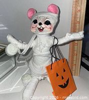 Front view of Annalee Mummy Mouse holding orange bag