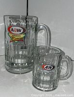 Large and small A&W clear glass mugs side by side