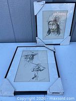 Both framed drawings with protective corner covers