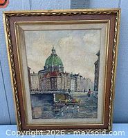 Full view of framed cityscape print in gold frame