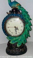 Front view showing peacock figure and clock face with Roman numerals