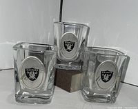 Three Raiders 2 oz square shot glasses front view showing pewter badges
