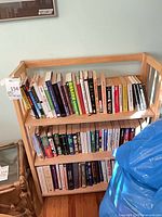 Front view of light wood bookcase filled with books