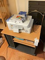 Printer on stand with cartridge box and guide sheet visible
