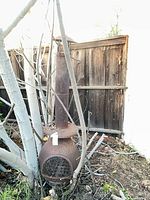 Full view of rusted chiminea among branches