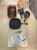 All nine cookware and bakeware pieces laid out