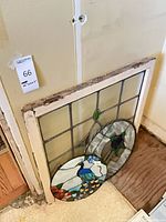 Rectangular panel and two round panels leaning against wall