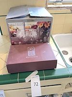 Boxes for punch bowl set and YUMING tea set on countertop