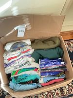 Open box showing stacked T-shirts