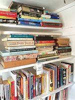 Overall view of three shelves filled with horizontally and vertically stacked books