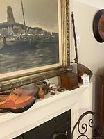 Mantel view showing painting, manual coffee grinder, copper scoop, turned wood canister, ceramic coasters, shells