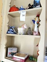 Shelf with pumpkin, windmill house, horse on wheels, tall bird figurine, boxed bowl and turtle shakers