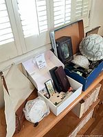 Full lot on shelf: blue box with turtle items, white box with misc décor, sailboat, bubble-wrapped piece visible