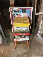 Overall lot showing chair with three boxed items stacked on seat