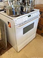 Full view of white Maytag gas range with cookware on top (not included)