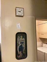 Overall view of wall clock and Coca-Cola tray mounted on wall