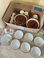 Boxed set showing mugs, covered pots, creamer and separate bowls