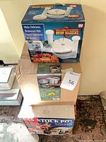 Three stacked boxes: Onion Machine, Tramontina multi-cooker, stock pot set