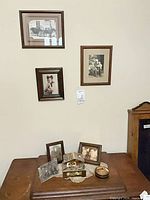 Overall view showing three wall-mounted framed photos and tabletop items
